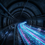 Aktuelles Bild: Tunnel with bright blue and pink streams of light representing flowing digital data